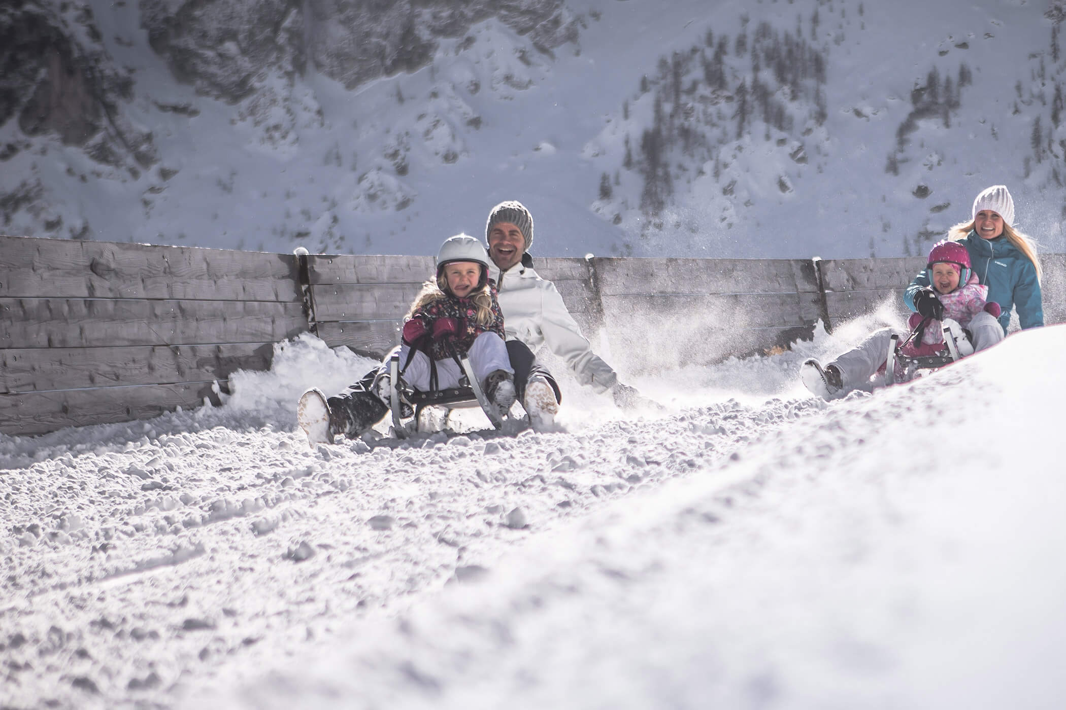 Parents and two daughters having fun on the toboggan run in the Dolomites - Laurin's