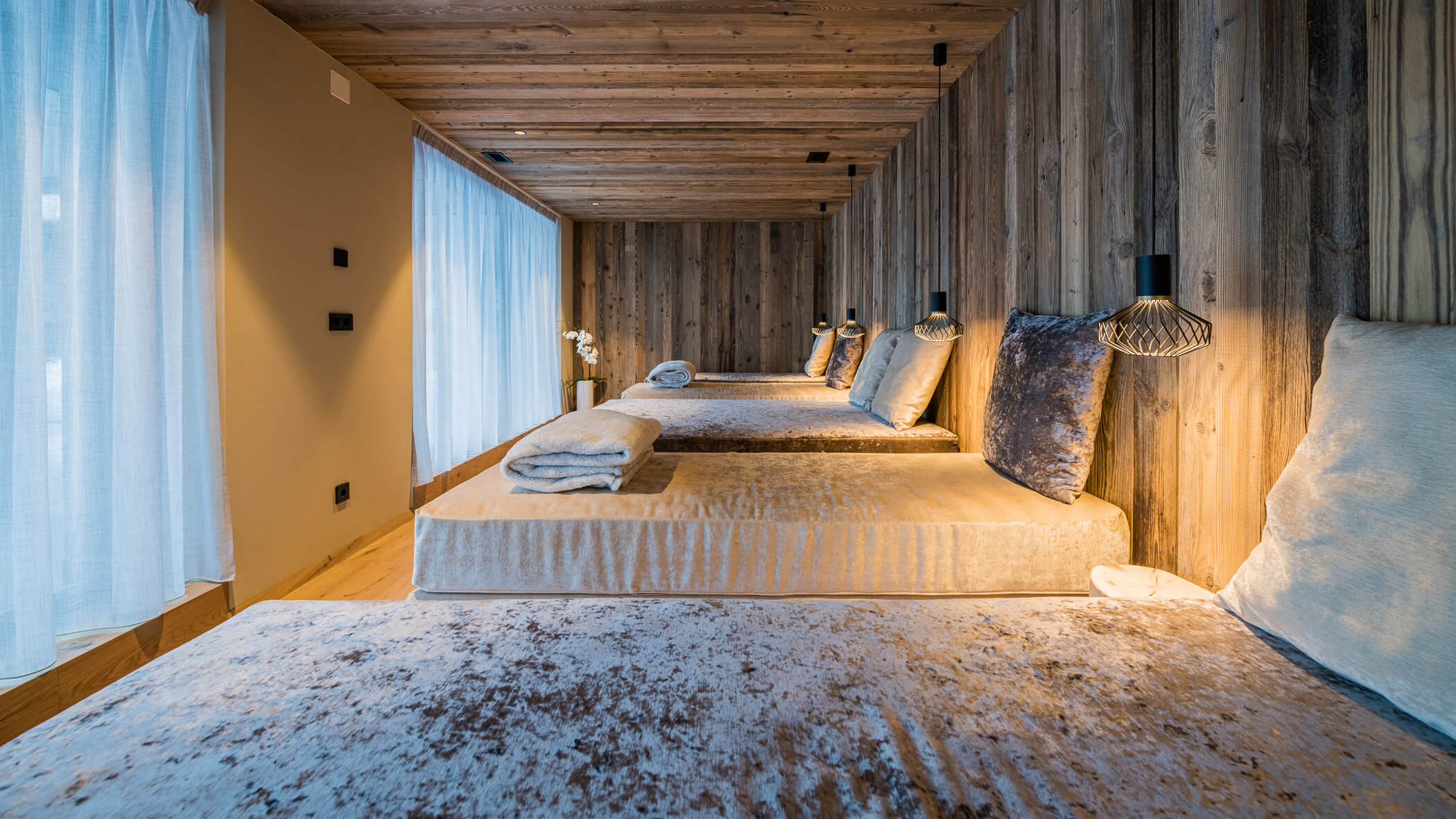 Ruheraum vom Wellnessbereich mit Holztäfelung und kuscheligen Liegen mit Pölster und Decken - Laurin's