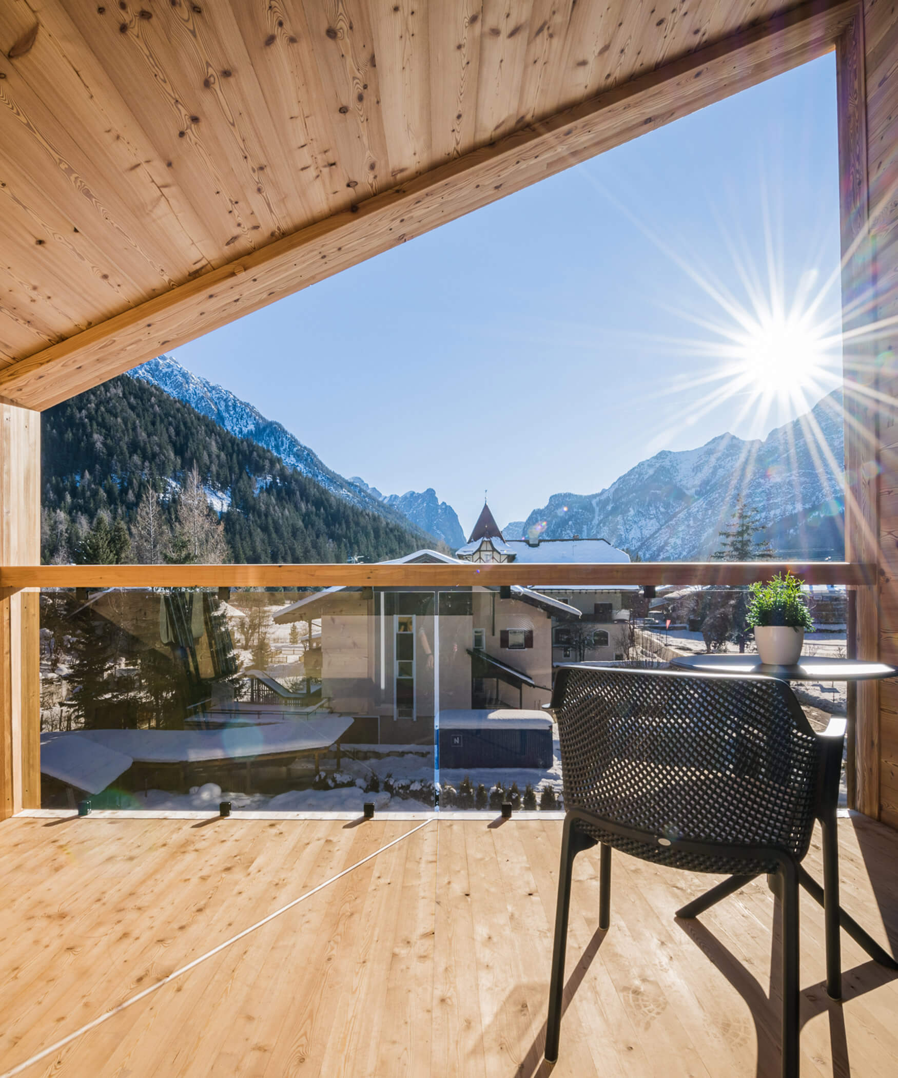 Modere Holzterrasse mit Glasbalkon und einer Sitzgelegenheit der Suite Mountain View mit sicht auf die Toblacher Berge - Laurin's