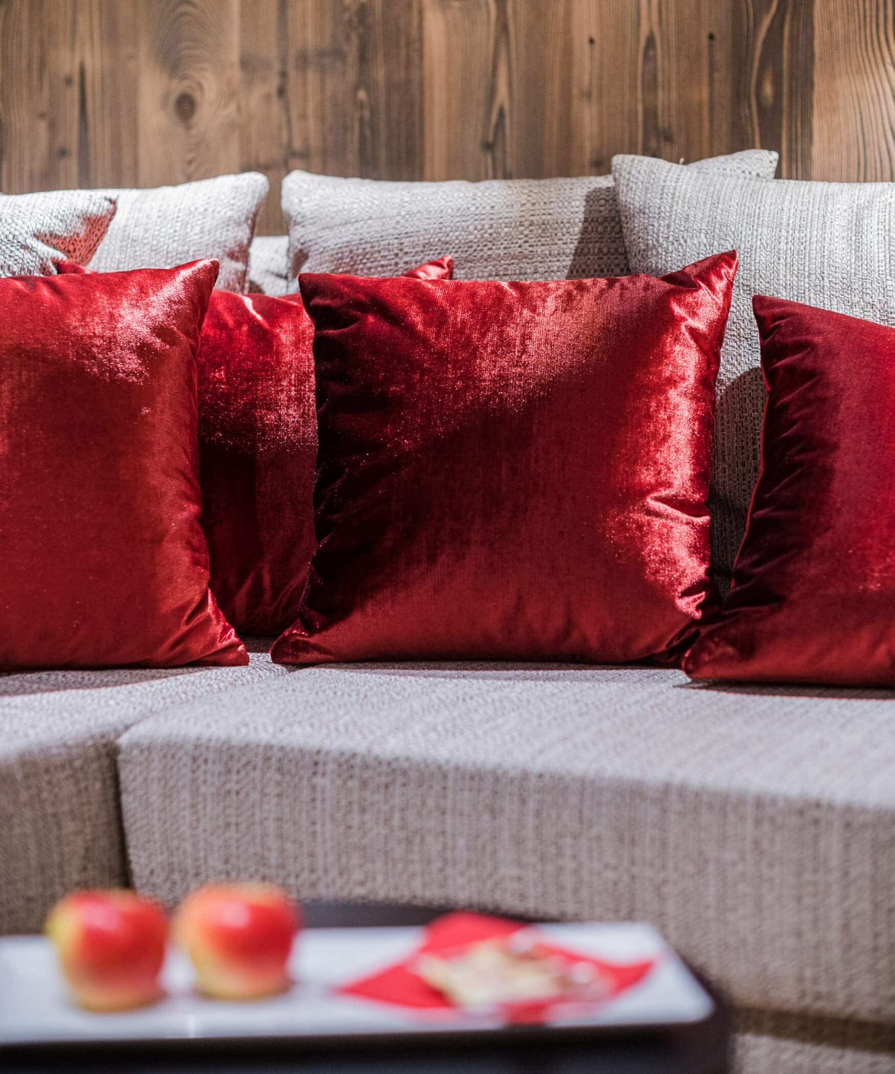 Graue Couch mit roten Kissen in der Chalet Suite - Laurin's
